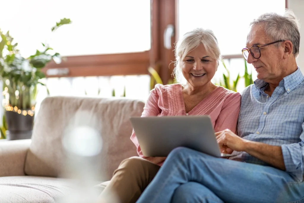elderly couple using laptop at home