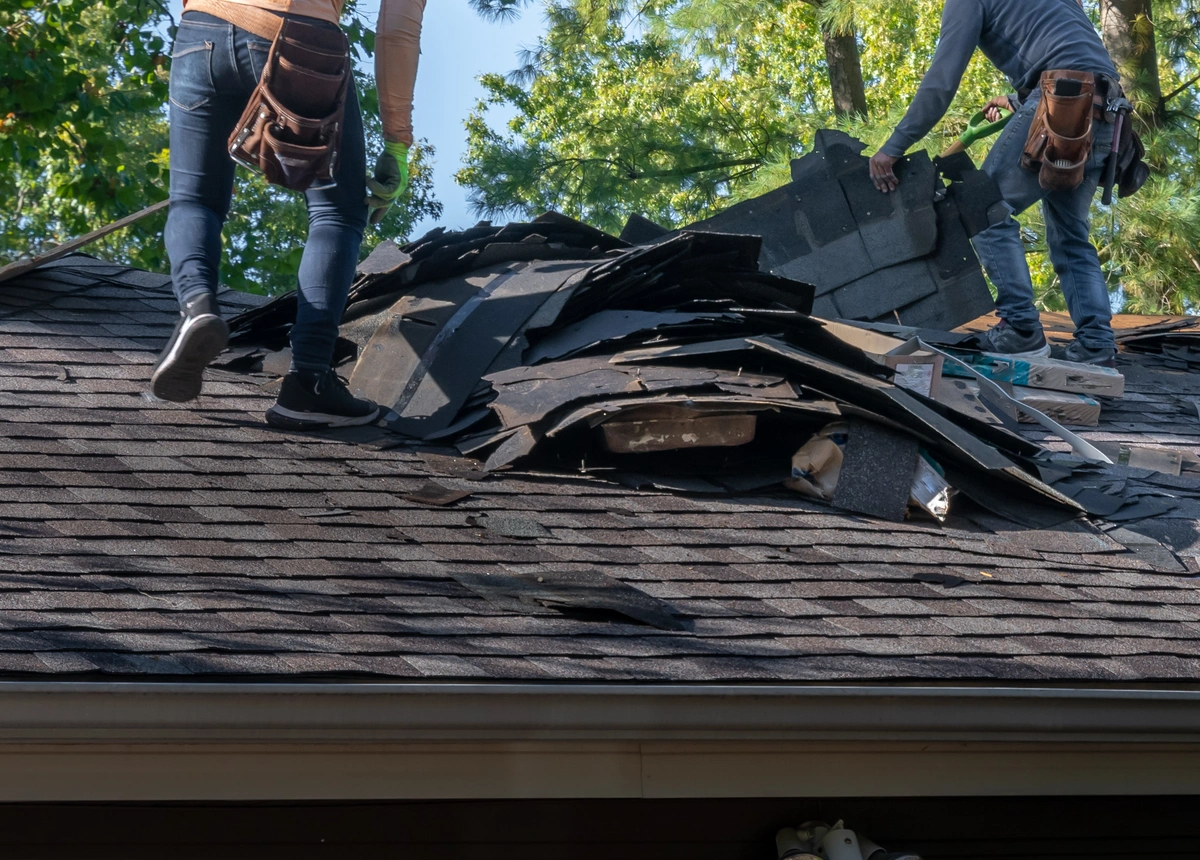 two guys tearing off a roof