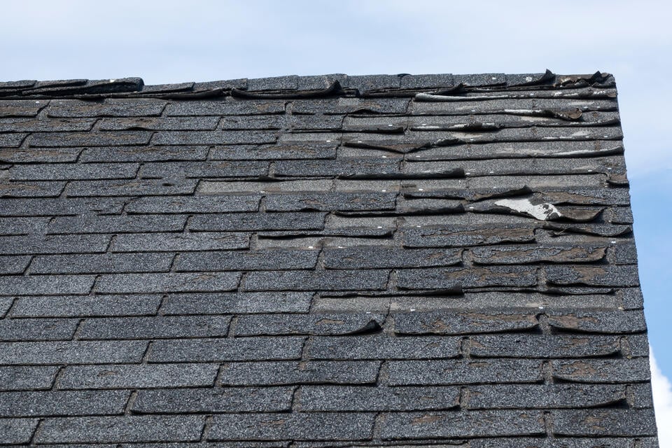 will insurance cover a 20 year-old roof-close up of old and damaged roof shingles