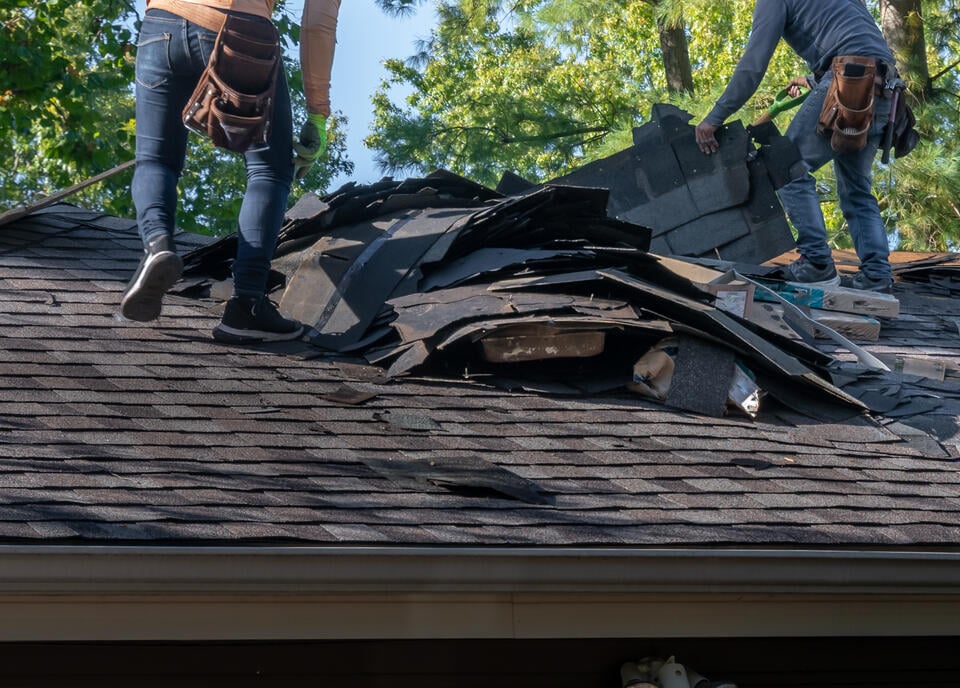 will insurance cover a 20 year-old roof-roofers removing old roofing materials for roof replacement