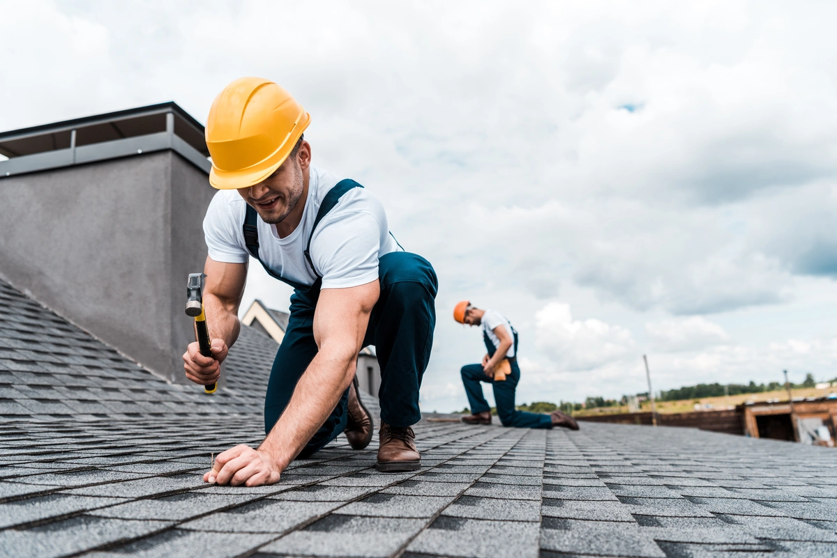 Construction worker installing shingles roof safety equipment