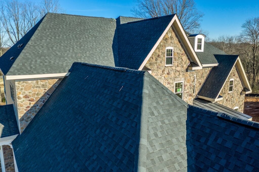 Aerial close-up view of a modern asphalt shingle roof with classic ridge, left and right rake on a newly constructed single family home in Maryland USA