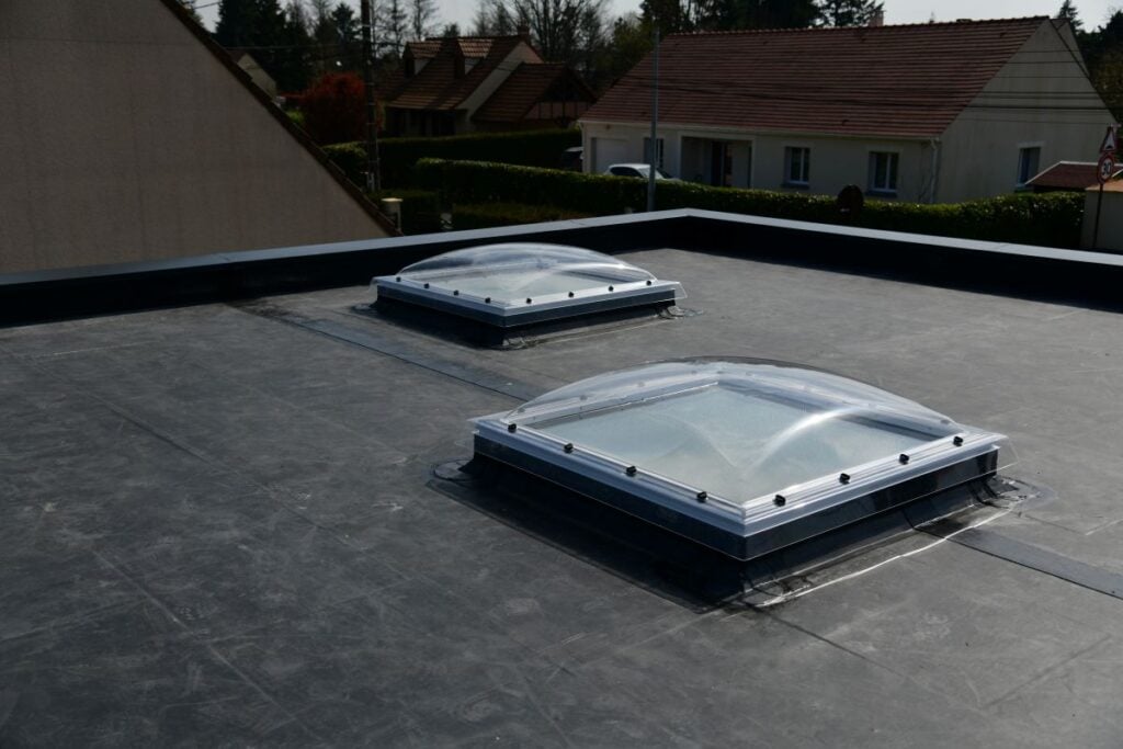 epdm roof repair commercial building two holes natural light surrounded by houses daylight