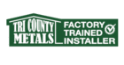 Green and white logo with a house-shaped outline reading "Tri County Metals" on the left and "Factory Trained Installer" with a check mark inside a gear on the right.